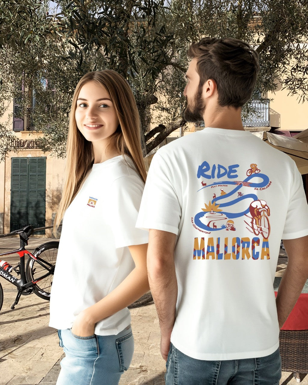 Two people wearing white t-shirts with a colorful graphic and text, standing outdoors.