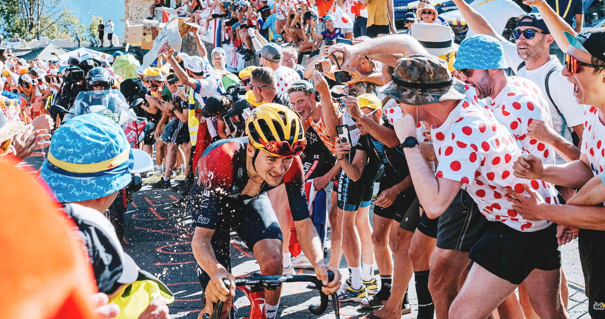 Crowds lining the hairpins of Alpe d'Huez as Tom Pidcock climbs at the Tour de France